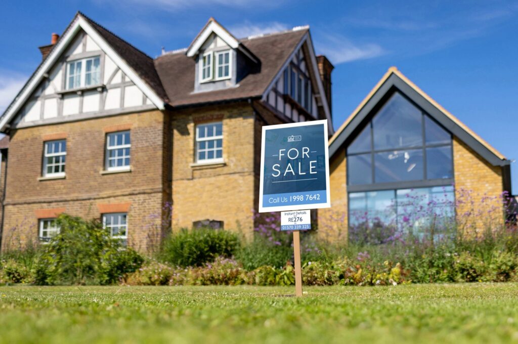House for sale with a real estate sign placed in the front yard